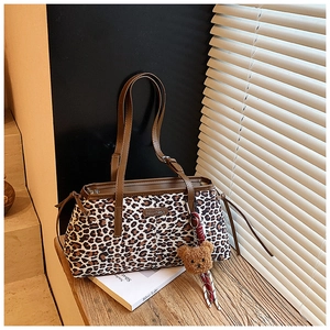 Détail du sac cabas imprimé léopard avec anses en cuir marron et pendentif ours peluche