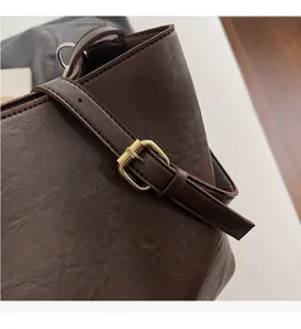 Detailed macro view of dark brown pebbled leather texture and gold metal buckle hardware