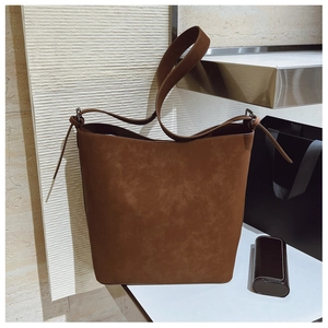 Detail view of brown vintage bucket bag showing matte leather texture and silver buckle