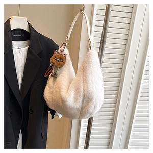 Détail du sac hobo en fausse fourrure blanche avec anse en cuir et charm animal marron