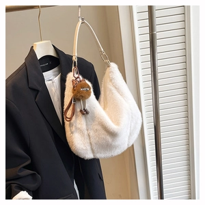 Détail du sac hobo en peluche blanche avec breloque marron et bandoulière en cuir