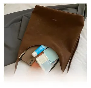 Interior view showing the large capacity of a brown suede hobo bag with personal items