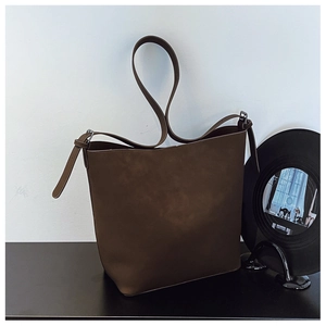 Detailed macro view of dark brown faux suede bucket bag with adjustable shoulder strap