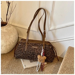 Détail du sac léopard avec bandoulière en cuir marron et breloque ours en peluche
