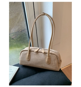 Detail view of apricot suede Boston bag with double zippers and soft texture