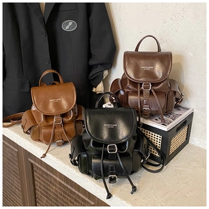 Three colors of faux leather backpacks with drawstring closure and metal buckles