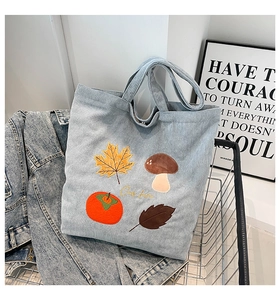 Détail de la broderie d'automne avec feuille d'érable sur un sac fourre-tout en velours