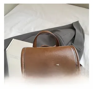 Detail of soft leather handle and fashion logo on vintage brown backpack for commuting