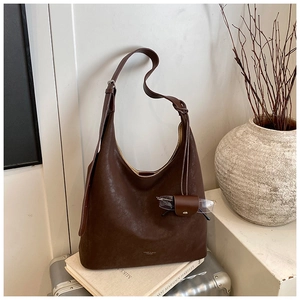 Détail du sac cabas marron foncé avec étui à lunettes en cuir sur la bandoulière