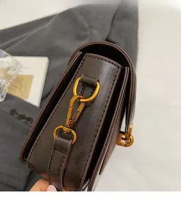 Dettaglio dell'hardware dorato vintage e attacco della tracolla su borsa in pelle