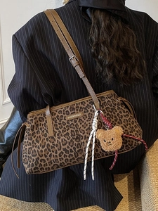 Sac fourre-tout léopard rétro avec sangles brunes et pendentif ours sur un costume noir