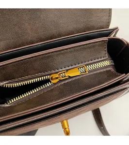 Dettaglio della borsa in pelle marrone vintage con cerniera in oro antico e vano interno