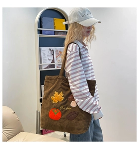 Détail de la broderie automnale sur un sac cabas en velours côtelé marron avec feuilles