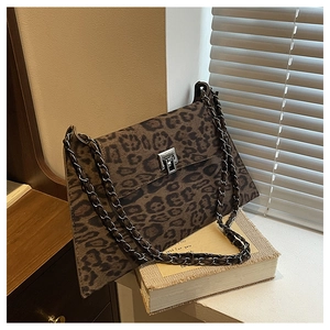 Detailed view of leopard print crossbody bag with silver chain strap and metal clasp