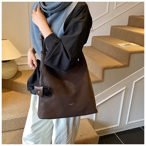 Détail du sac cabas marron foncé minimaliste avec texture cuir mat et petit logo