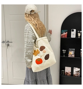 Détail de la broderie de plantes automnales sur un grand sac cabas en velours côtelé