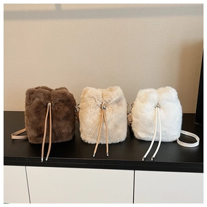 Nahaufnahme von flauschigen Plüsch-Beuteltaschen in Dunkelbraun, Beige und Weiß