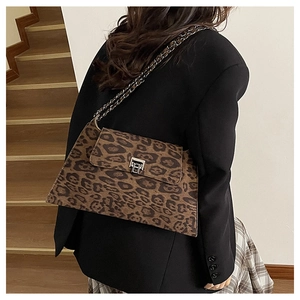 Close-up of leopard print shoulder bag with silver metal lock and chain strap detail