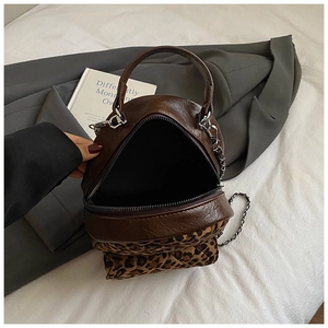 Détail du mini sac à dos avec garniture motif léopard et bandoulière chaîne argentée