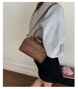 Detail of vintage dark brown Boston bag featuring matte leather texture and front pocket
