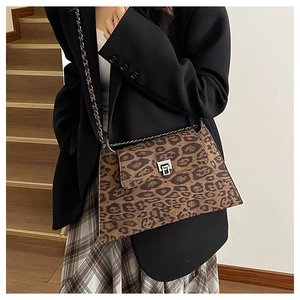 Close-up of leopard print crossbody bag with silver twist lock and chain strap detail