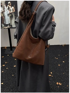 Détail d'un sac cabas marron foncé en similicuir montrant la texture et le logo