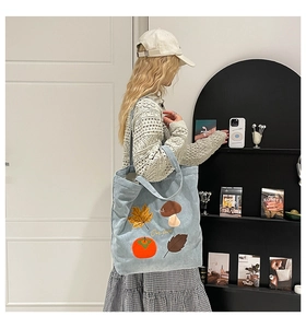 Détails de broderie d'automne et texte One Love sur un grand sac cabas en velours côtelé