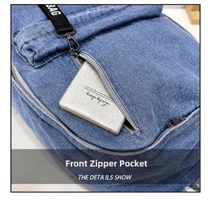 Detailed view of the front zipper pocket on a blue denim backpack with a lucky diary inside