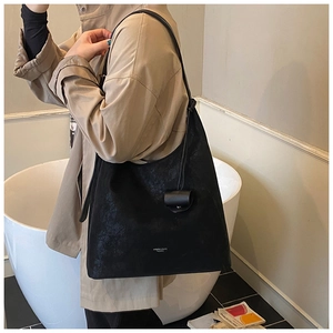 Détail du grand sac cabas noir en cuir avec pochette suspendue et texte de mode gravé