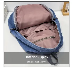 Interior view showing large compartment and zipper pocket of navy denim backpack