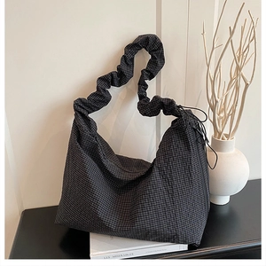 Detail of plaid canvas hobo bag with pleated strap and side drawstring accent