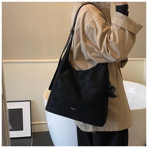 Detail of a large black vintage tote bag with fine matte texture and subtle brand logo