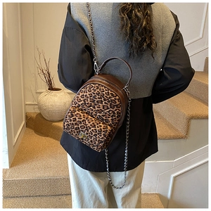 Détail d'un sac à dos léopard avec texture matelassée et bandoulière en chaîne métal