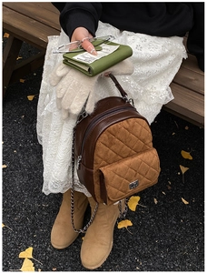 Détail d'un mini sac à dos matelassé avec poignée en chaîne et textures rétro