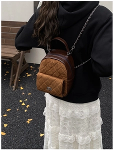 Détail d'un mini sac à dos léopard avec matelassage, chaîne en métal et fermoir rotatif argenté
