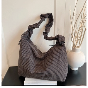 Detail of checkered canvas hobo bag featuring a gathered scrunchie style shoulder strap