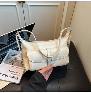 Close-up of cream leather shoulder bag with silver buckle and adjustable strap detail