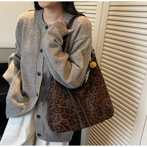 Detail of leopard print tote bag with yellow charm and grey knitted cardigan texture