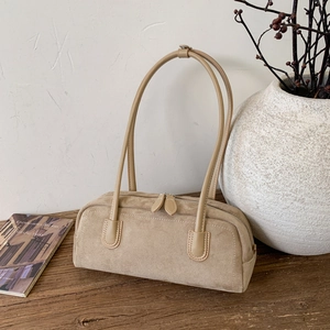 Close-up of khaki suede texture and zipper detail on this vintage baguette shoulder bag