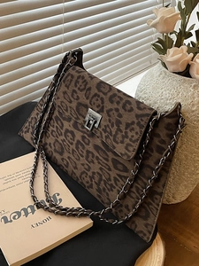Retro leopard print crossbody bag with chain strap and gold hardware in a chic setting
