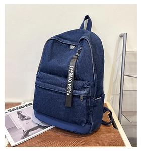 Detail shot of navy blue denim backpack showing textile texture and trendy fashion ribbon