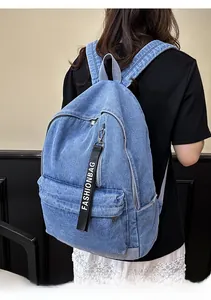 Detail of light blue denim backpack showing fashion strap and washed denim texture
