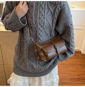 Brown matte faux leather pillow bag with adjustable strap shown on a model