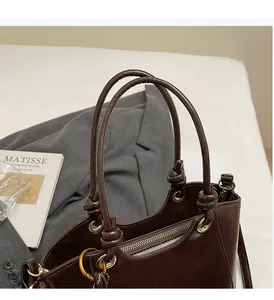 Détail du sac seau marron montrant la poignée nouée renforcée et les œillets en métal