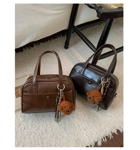 Détail de sacs fourre-tout marron avec boucle vintage et joli pendentif ours en peluche
