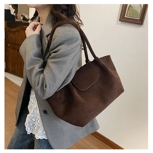 Brown faux suede tote bag with flap closure styled with grey blazer and jeans