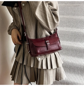 Elegant deep burgundy faux leather shoulder bag styled with a beige blazer suit