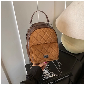 Détails d'un sac à dos matelassé vintage avec cuir, chaîne en métal et fermoir rotatif