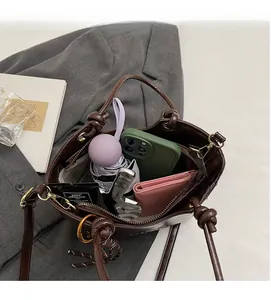 Vue détaillée du grand espace intérieur du sac seau marron avec divers accessoires inclus