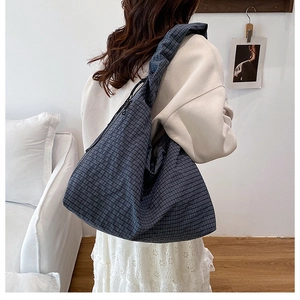 Detail of navy blue checkered hobo bag with pleated shoulder strap and drawstring